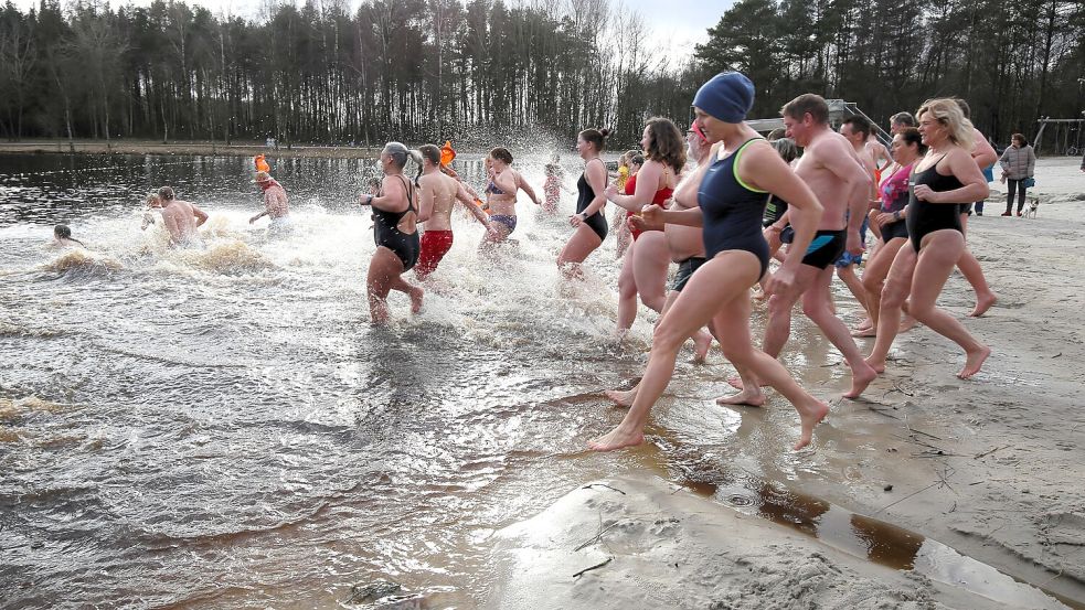In diesem Jahr rannten besonders viele Mutige mit der DLRG-Ortsgruppe Wiesmoor-Großefehn zum Anbaden ins Ottermeer. Foto: Böning