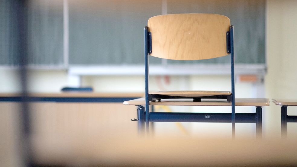 Ein Stuhl steht in einem Klassenzimmer auf einem Tisch. Foto: DPA