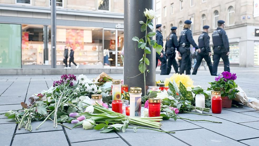 Kerzen und Blumen liegen in der Nähe des Paradeplatzes in Mannheim an einer Straßenbahnhaltestelle. (Archivfoto) Foto: Uli Deck/dpa