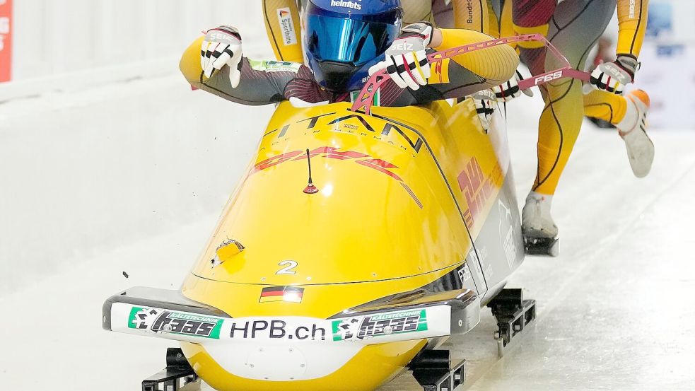 Johannes Lochner beim Start, links im Bob ist das Loch zu sehen. Foto: Seth Wenig/AP/dpa