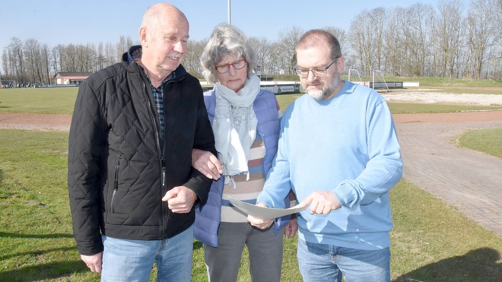 Die Initiatoren des Bürgerbegehrens für den Erhalt des Sportplatzes in Upgant-Schott, Claus-Dieter Freimuth (von links), Hanna Barkhoff und Jens Albowitz schauen gemeinsam auf den ablehnenden Bescheid der Verwaltung. Foto: Thomas Dirks