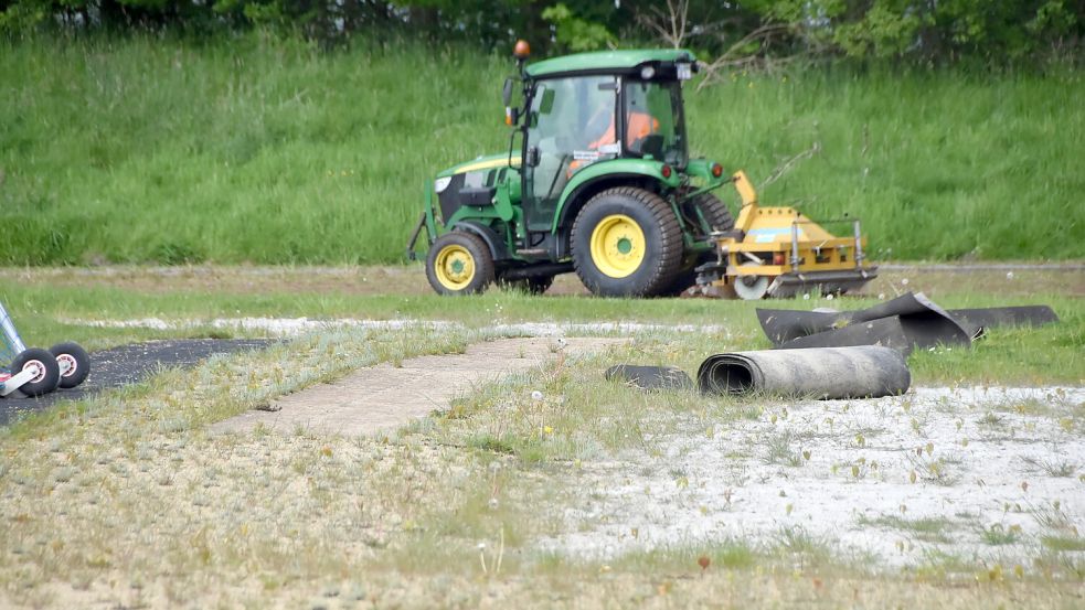 Ein Trecker bearbeitet die Laufbahn im Sportzentrum in Upgant-Schott. Das seltene Bild entstand am 8. Mai 2024. Die alten Anlagen werden von der Samtgemeinde kaum noch gepflegt. Foto: Thomas Dirks