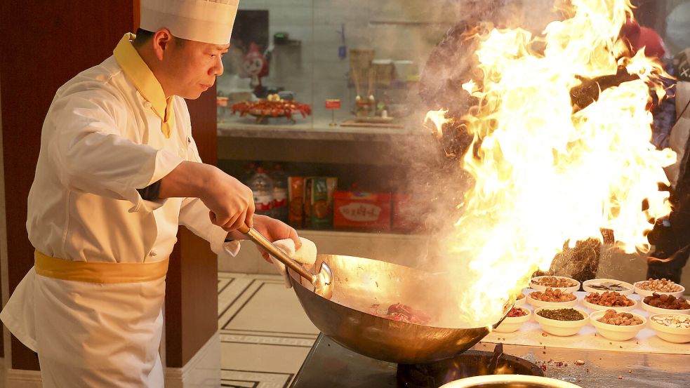 Ein chinesischer Koch bereitet chinesisches Essen zu. Foto: imago-images/Xinhua
