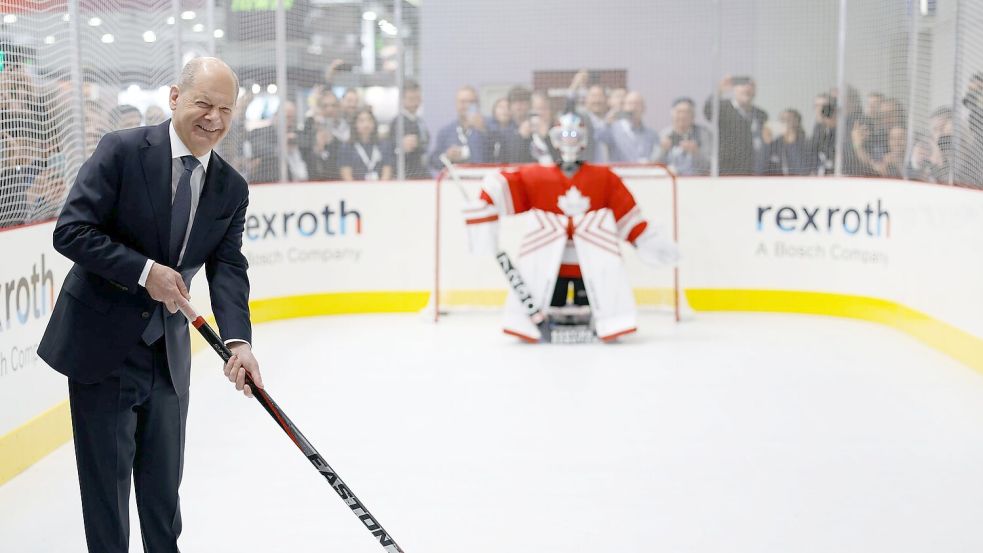 Knapp daneben ist auch vorbei: Das Eishockey-Duell zwischen Scholz und dem „Robo Goalie“ endete ohne Treffer. Foto: Michael Matthey/dpa