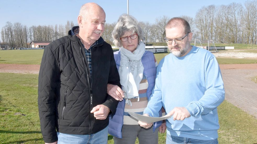 Die Initiatoren des Bürgerbegehrens für den Erhalt des Sportplatzes in Upgant-Schott, Claus-Dieter Freimuth (von links), Hanna Barkhoff und Jens Albowitz blicken auf den ablehnenden Bescheid der Verwaltung. Foto: Thomas Dirks