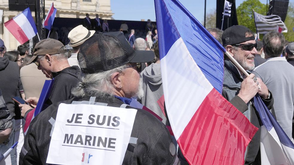 Menschen nehmen in der Nähe des Parlaments an der Kundgebung der rechten Partei Rassemblement National (RN) nach dem Ausschluss der Rechtspopulistin Marine Le Pen von Wahlen durch ein Gericht teil. Ein Teilnehmer trägt ein Schild auf dem Rücken „Je suis Marine“. Foto: DPA/Michel Euler