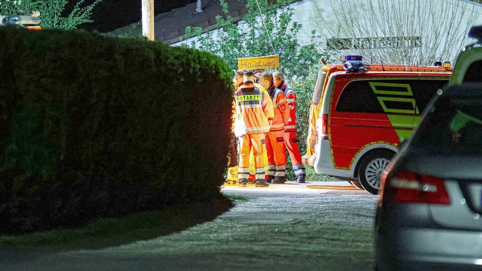 Helfer und ein Notarzt stehen in einer Kleingartenanlage in Wuppertal. Sie können nicht mehr helfen. Foto: Florian Schmidt/dpa