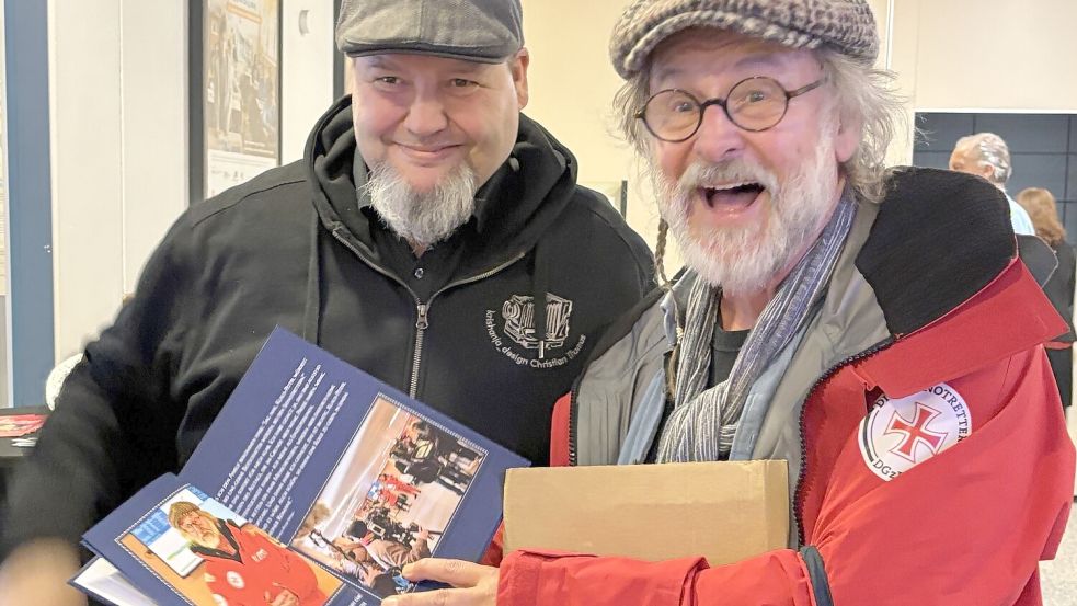 Klaus-Peter Wolf (rechts) bekam ein Buch zu seiner Arbeit auf dem Seenotrettungskreuzer geschenkt. Foto: Rebecca Kresse