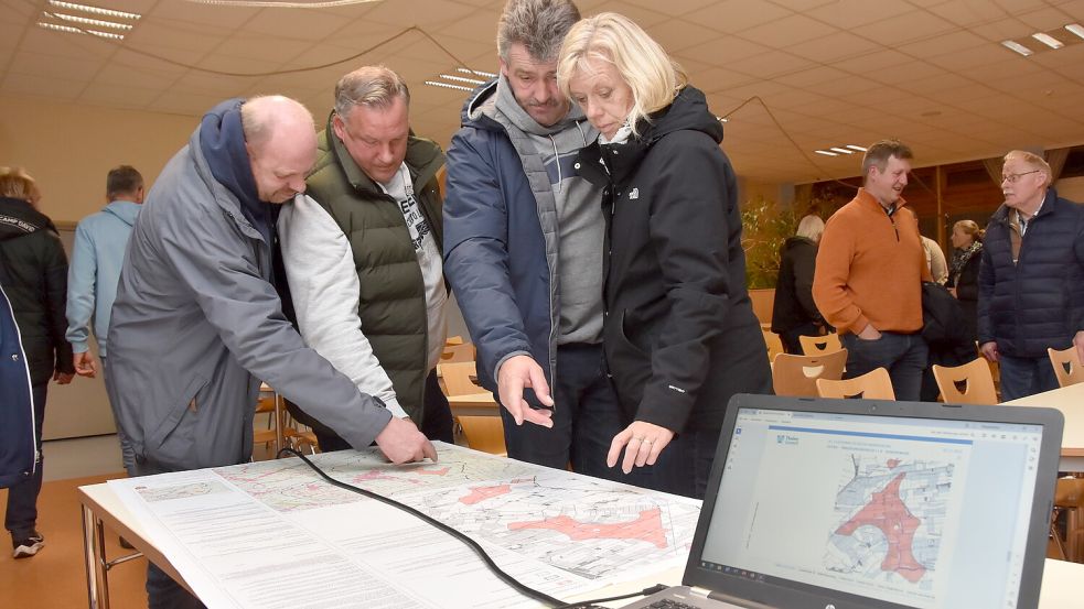 Teilnehmer eine Veranstaltung zu Thema Windkraft im Jahr 2023 betrachten Karten, auf denen die Flächen für den Bau weiterer Windkraftanlagen eingezeichnet sind. Foto: Thomas Dirks