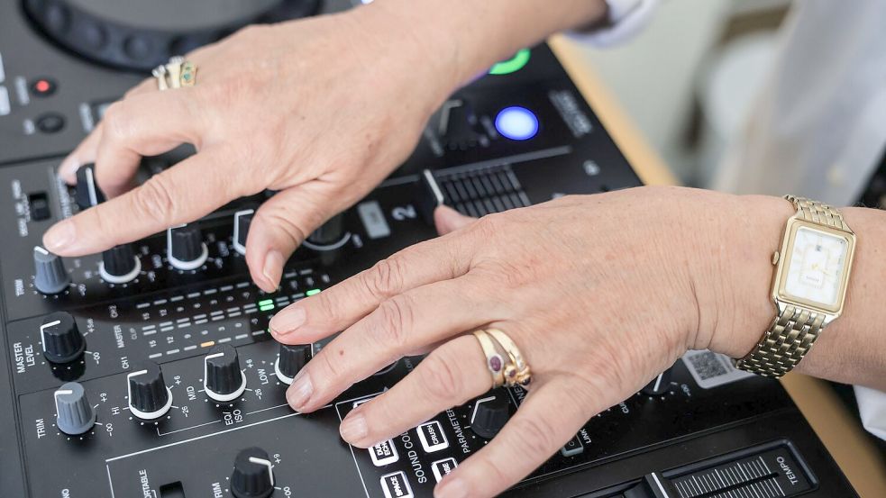 Diese Hände sind 73 Jahre alt: In einem Kurs in Köln lernen Seniorinnen, wie man DJ wird. Foto: Oliver Berg/dpa