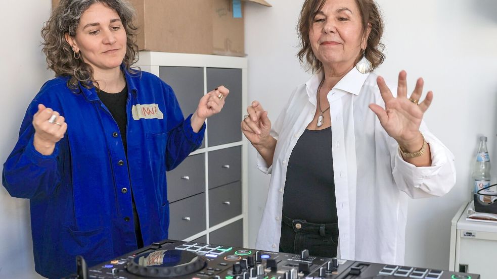 Dozentin Anna Cainelli (links) hilft DJ-Schülerin Ingrid Jatho, das Lied „Bauch Beine Po“ zu spielen. Foto: Oliver Berg/dpa