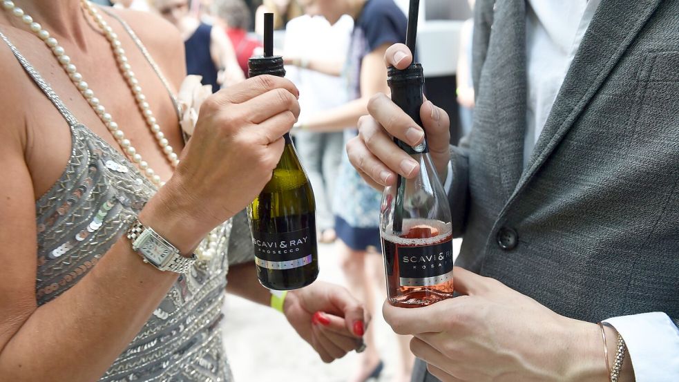 Small Talk mit Prosecco: Gäste unterhalten sich am Rande einer Modenschau in Berlin. (Archivbild) Foto: picture alliance / ZB