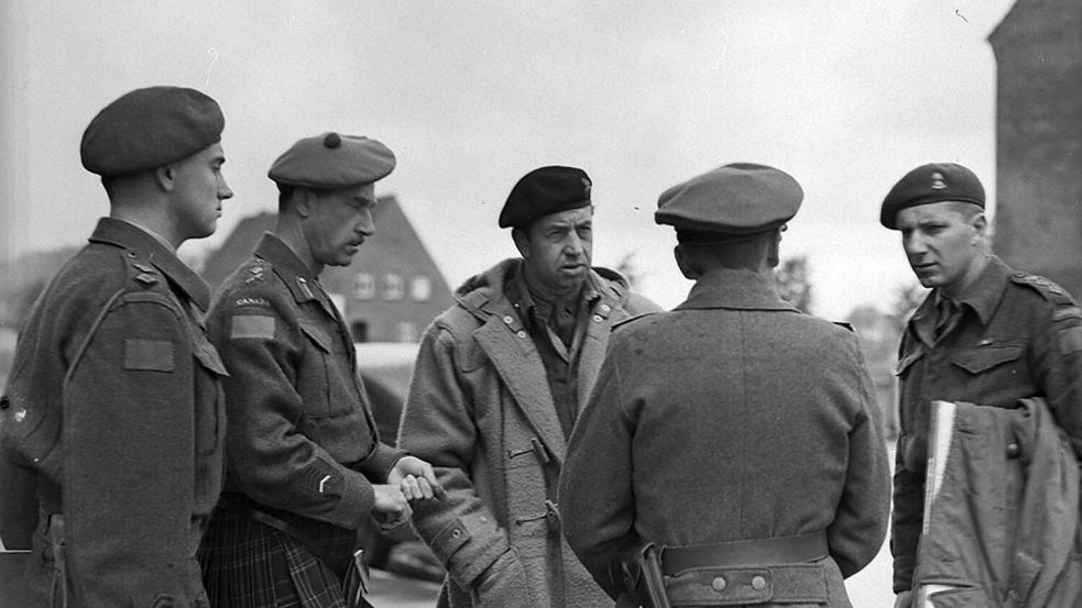 Major General R.H. Keefler (2. von links), und Brigadier J.A. Roberts (Mitte), mit ihrem Dolmetscher Captain R. Pootmans (rechts), und einem weiteren kanadischen Offizier (links), sprechen mit Adjutant Oberleutnant Fischer (2. von rechts) in der Blücher-Kaserne in Aurich am 5. Mai 1945. Foto: © Library and Archives Canada