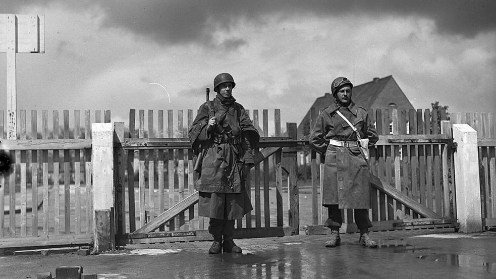 Ein deutscher und ein kanadischer Soldat bewachen am 5. Mai 1945 gemeinsam den Eingang der Auricher Blücher-Kaserne. Foto: © Library and Archives Canada