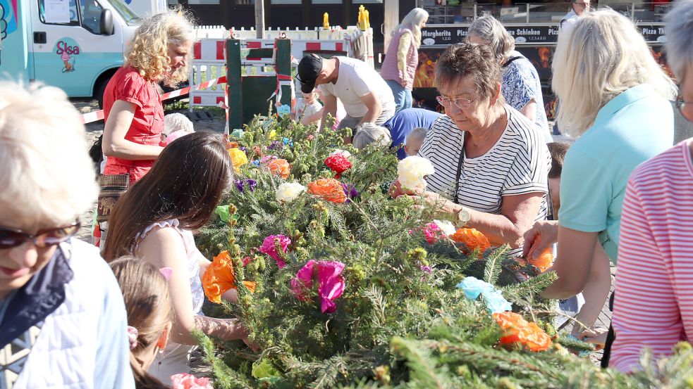 Die Mitglieder des Auricher Schützenvereins haben dafür gesorgt, dass der Auricher Maibaum mit vielen bunten Papierblumen geschmückt werden konnte Foto: Romuald Banik