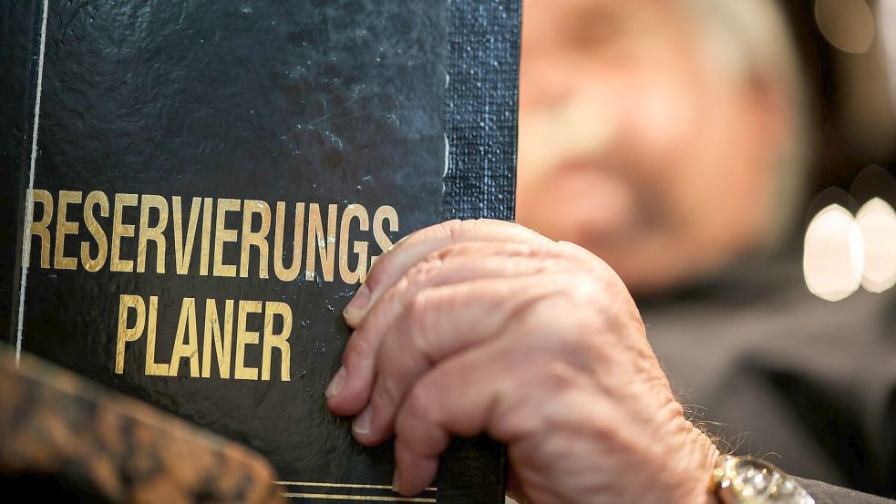 Altmodisch? Ein Gastronom schaut in sein Reservierungsbuch. Foto: Christoph Reichwein/dpa