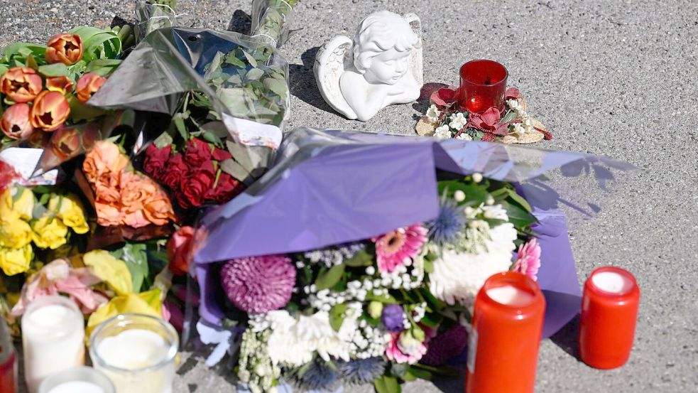 Zeichen der Anteilnahme: Auf einem Bürgersteig an dem Spielplatz sind Kerzen und Blumen niedergelegt worden. Foto: Roberto Pfeil/dpa