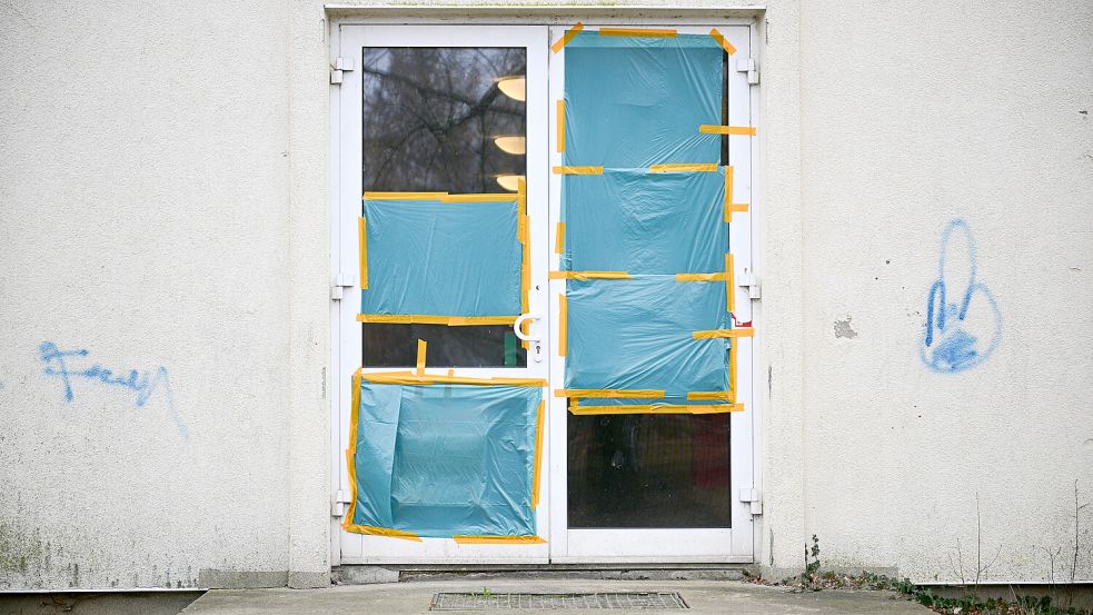 Planen decken an einer Unterkunft für Geflüchtete die beschädigten Scheiben einer Tür ab. Das Übergangswohnheim in Stahnsdorf war im März angegriffen worden. Foto: dpa/Sebastian Christoph Gollnow