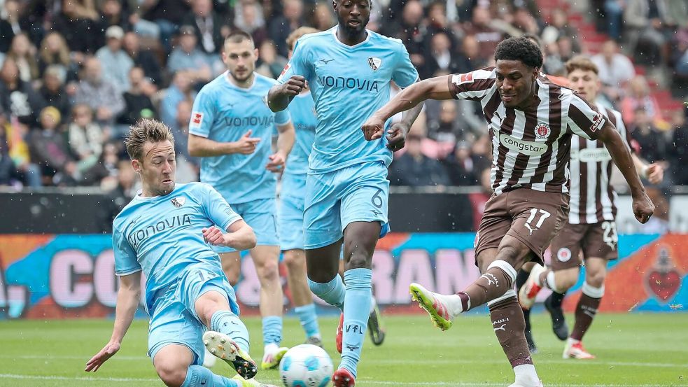 St. Paulis Oladapo Afolayan (r) und Bochums Felix Passlack (l) kämpfen um den Ball. Foto: Christian Charisius/dpa