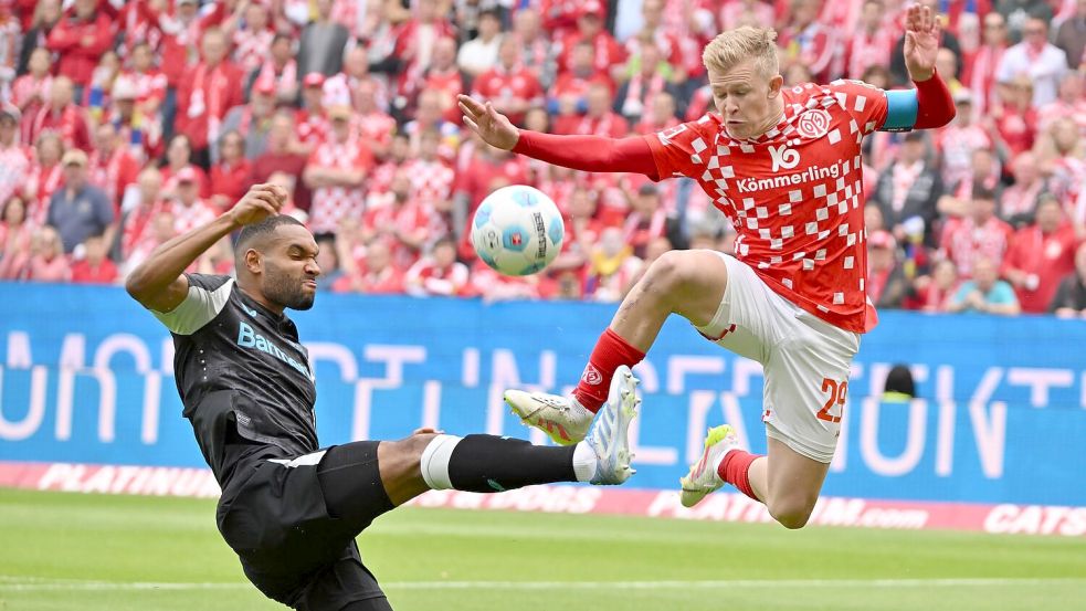 Der FSV Mainz 05 um Jonathan Burkardt (r) zeigte gegen Bayer Leverkusen um Jonathan Tah (l) eine bärenstarke erste Hälfte. Foto: Torsten Silz/dpa