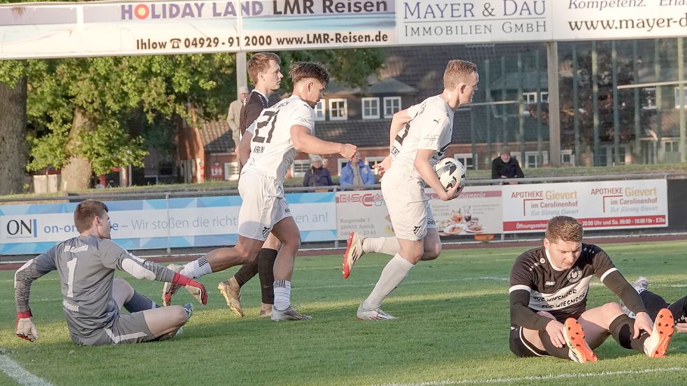 Die Wiesmoorer Tim Barth (links) Waldemar Schott (rechts) nach dem Anschlusstreffer der Auricher zum 1:2 am Boden. Auf zum Mittelkreis: Klaas Folkerts mit dem Ball in der Hand hat es eilig. Im Schlepptau Simon Smit. Fotos. Helmut Vortanz