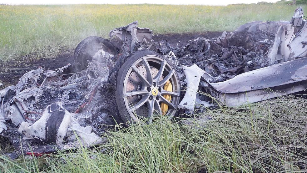 Der Sportwagen brennt neben der Autobahn aus. Foto: Reinert/swd-medien /dpa