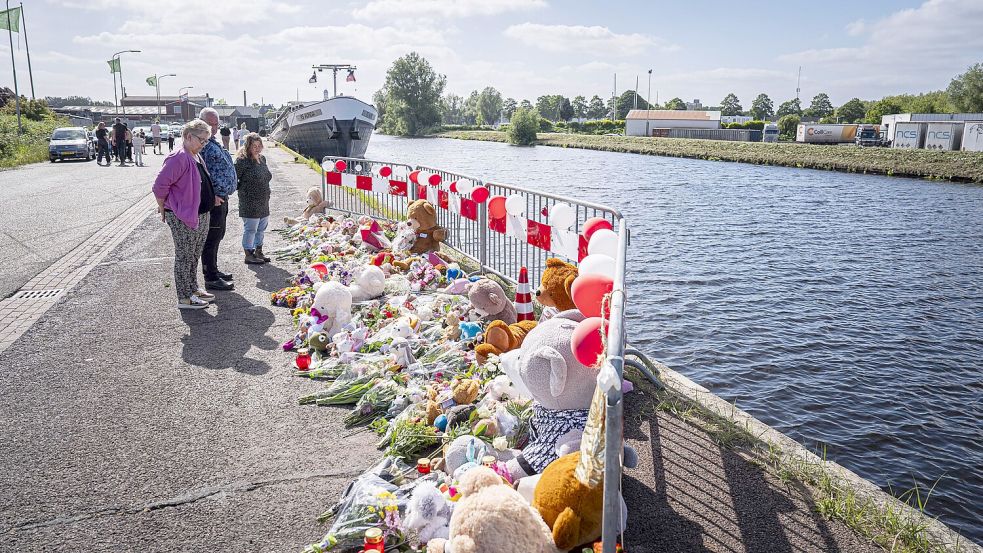 Menschen stehen an einer Gedenkstätte vor Blumen und Stofftieren. Foto: Jaspar Moulijn/ANP/dpa