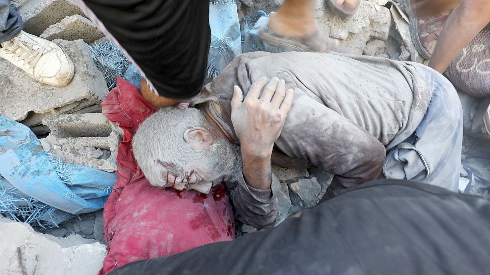 Palästinenser nach dem Angriff auf Gebäude im Flüchtlingsviertel Al-Bureidsch. Foto: Moiz Salhi/APA Images via ZUMA Press Wire/dpa