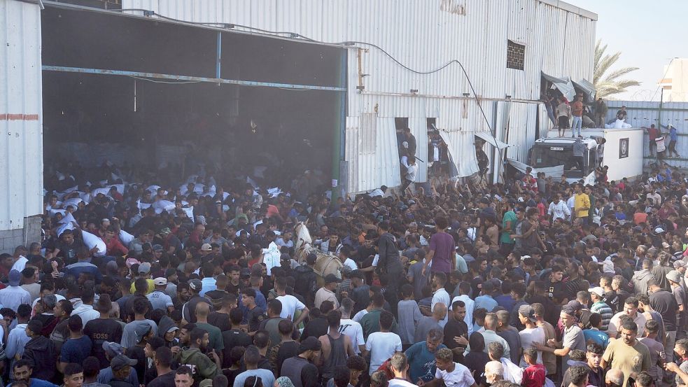 Palästinenser tragen Säcke mit Mehl, nachdem sie ein Lagerhaus des Welternährungsprogramms der Vereinten Nationen in Zawaida im zentralen Gazastreifen gestürmt haben. Foto: Abdel Kareem Hana/AP/dpa