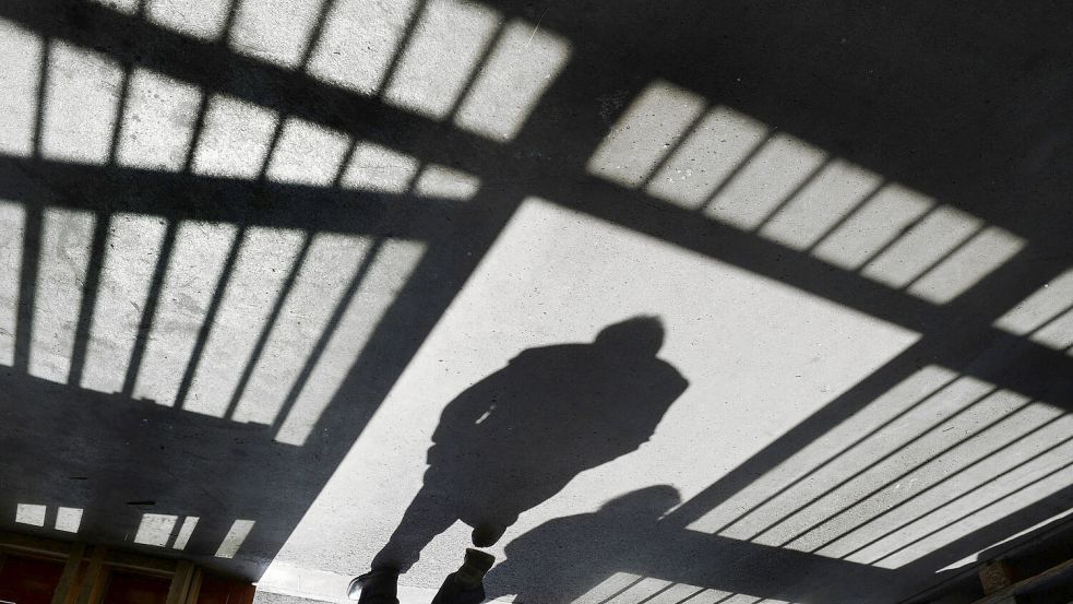 Der Schatten eines Mannes fällt durch die Tür einer JVA. Foto: DPA