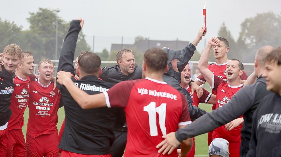 Mannschaft und Funktionsteam des VfB Münkeboe feiern ausgelassen nach der überstandenen Relegation den Verbleib in der Fußball-Ostfrieslandklasse A. Fotos: Wilfried Gronewold