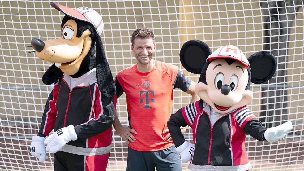Thomas Müller mit Goofy und Micky Maus. Foto: Sven Hoppe/dpa