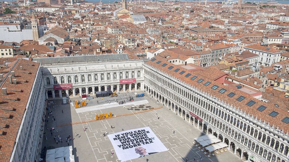 Greenpeace protestiert mit einem großen Transparent auf dem Markusplatz in Venedig gegen die Bezos-Hochzeit. Foto: Greenpeace/Greenpeace/AP/dpa