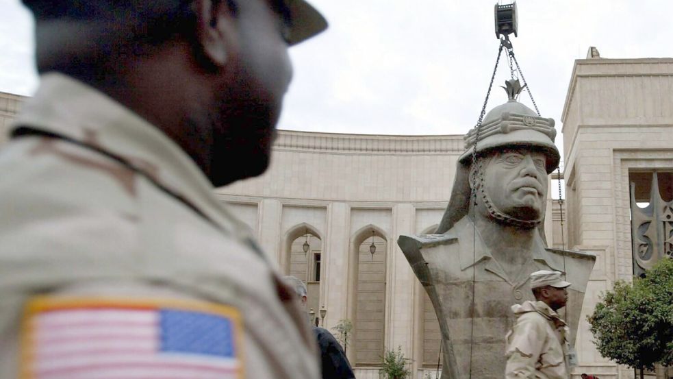 Eine Bronzestatue des früheren irakischen Diktators Saddam Hussein wird in Bagdad mit einem Kran demontiert. Foto: dpa/DB Petar Kujundzic