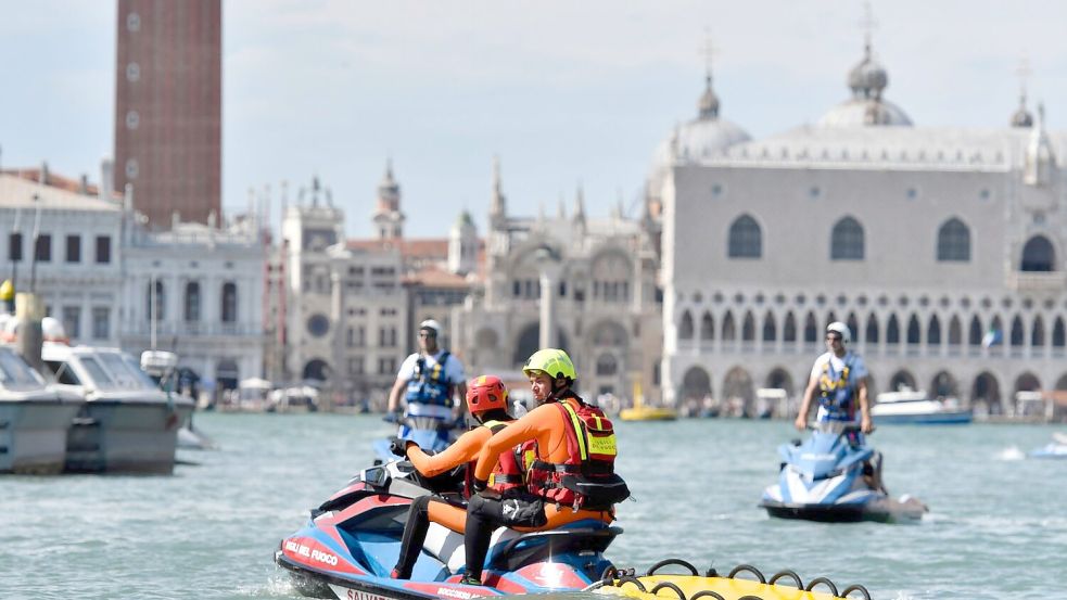 Die Polizei war auch mit Jet-Skis im Einsatz. Foto: Luigi Costantini/AP/dpa