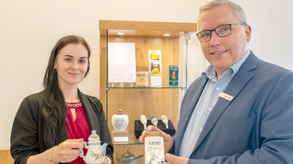 Teemuseumsleiterin Mirjana Ćulibrk und der Marienhafer Sparkassenfilialleiter Jochen Toben zeigen einige der ausgestellten Exponate. Foto: Folkert Bents