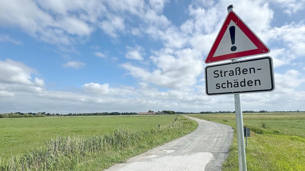 Mit Schildern weist die Gemeinde auf die teils massiven Straßenschäden hin. Einige Stellen wurden provisorisch mit Schotter aufgefüllt. Foto: Holger Janssen