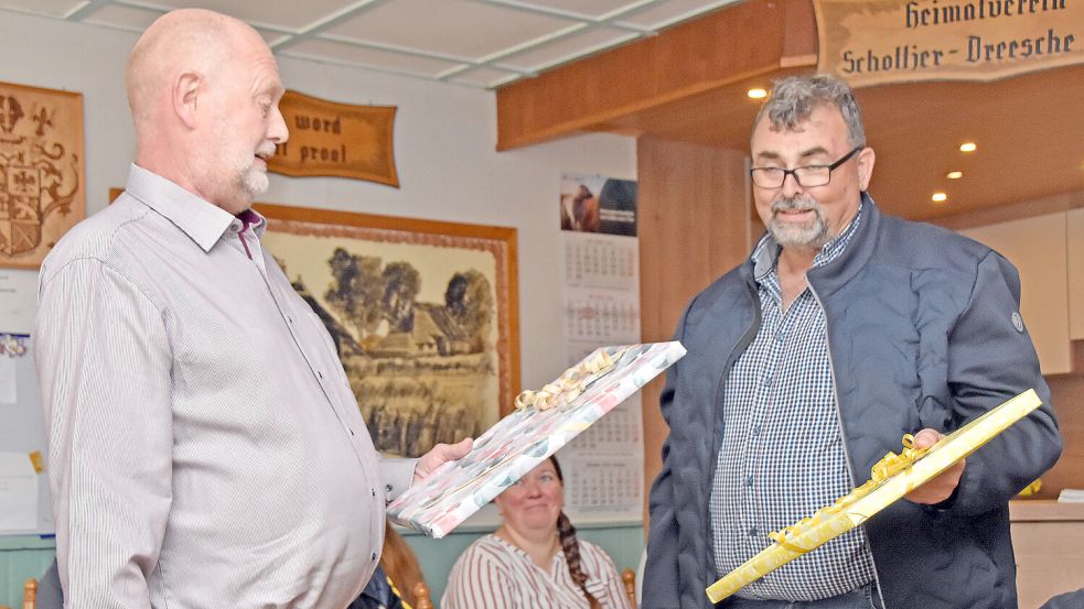 Upgant-Schotts Bürgermeister Günter Winter (SPD, rechts) überreichte seinem Ratskollegen Albert Janssen als Abschiedsgeschenk eine Gemäldereproduktion mit Landschaftsmotiv. Foto: Thomas Dirks