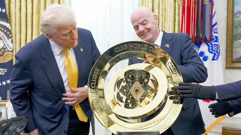 US-Präsident Donald Trump (l) und FIFA-Präsident Gianni Infantino mit der goldenen WM-Trophäe im Oval Office des Weißen Hauses. Foto: Uncredited/Pool/AP/dpa