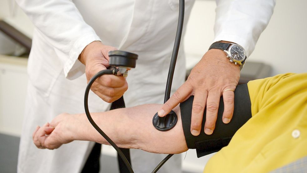Ein Hausarzt misst in seiner Praxis einer Patientin den Blutdruck. Foto: Weißbrod/dpa