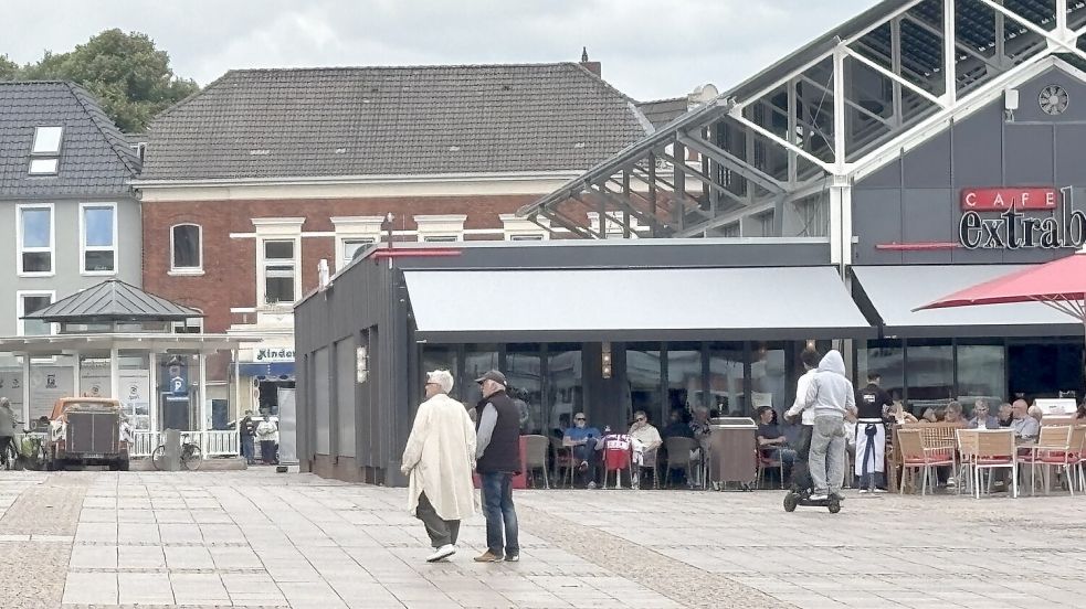 Zwei junge Männer fahren gemeinsam mit einem E-Scooter über den Auricher Marktplatz. Auch das Fahren zu zweit auf einem Scooter ist eigentlich verboten. Foto: Eva van Loh