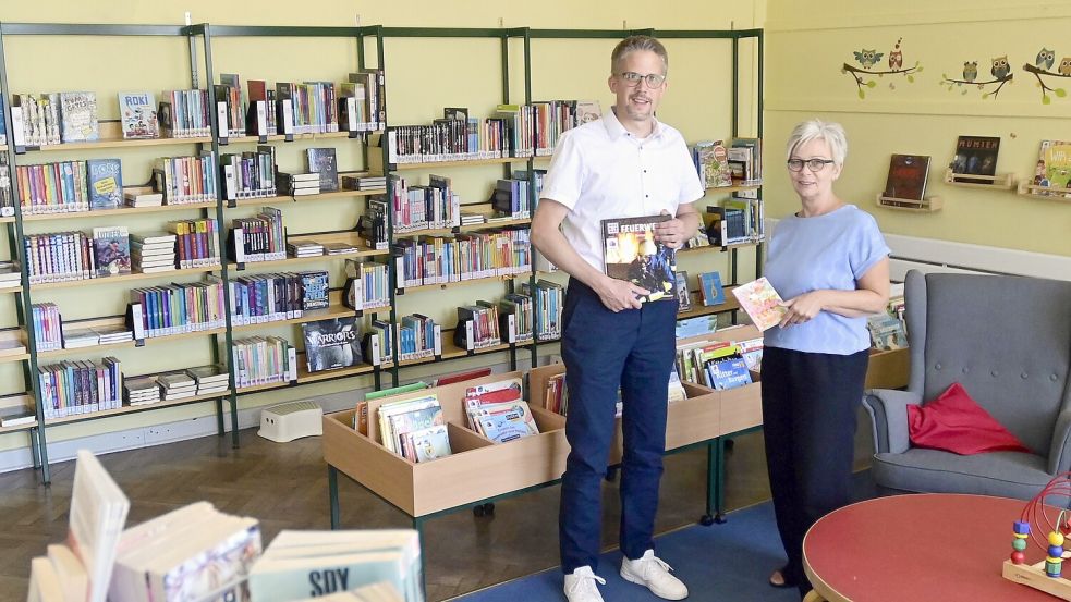 Der Großefehntjer Erste Gemeinderat Frank Cramer und Thea Wolters, Leiterin der Bücherei, freuen sich über die neuen Angebote. Foto: Gemeinde Großefehn