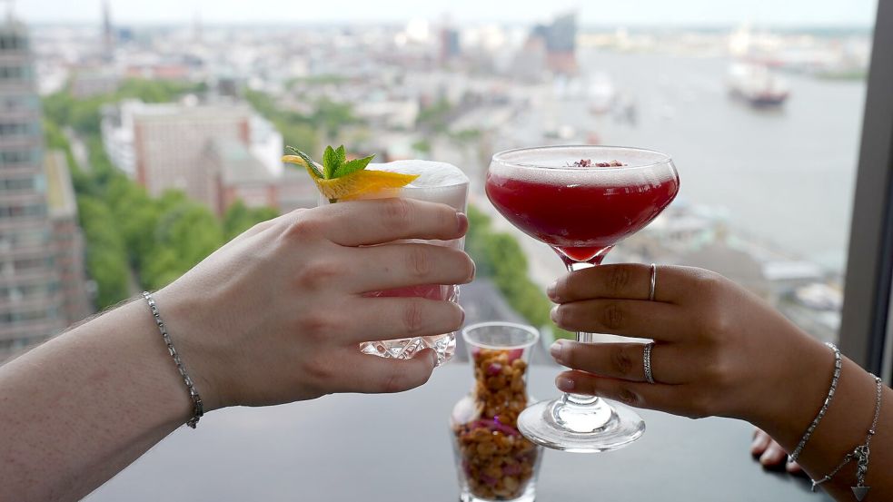 Prost mit Cocktails: Viele berichten einer Umfrage zufolge, dass sie weniger ausgehen und auch weniger ihre Freunde treffen angesichts der Inflation der letzten Jahre. Foto: Marcus Brandt/dpa