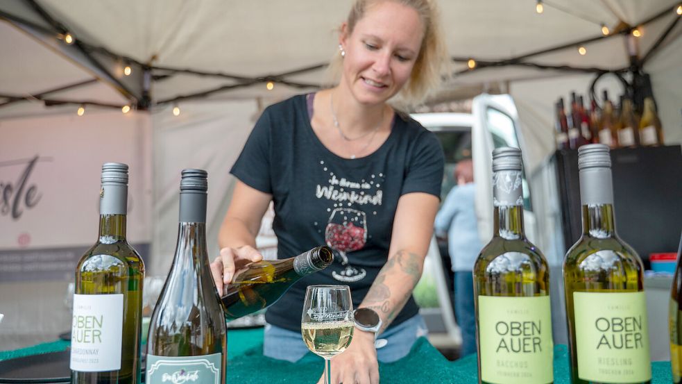 Carina Schulz von der Weinkiste in Südbrookmerland füllt ein Glas mit Weißwein. Foto: Folkert Bents