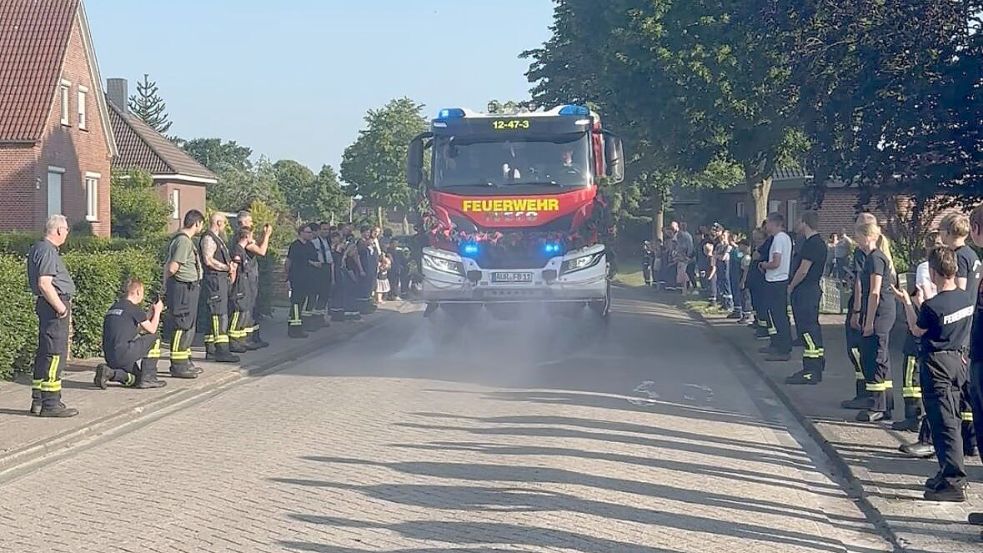 Spalier für das jüngste Gefährt im Fuhrpark: Feuerwehrleute verschiedenen Alters aus Osteel und Leezdorf säumten den Alten Postweg in Osteel, als dort im Juni das neue LF 20 eintraf. Foto: Feuerwehr/Carsten Redenius