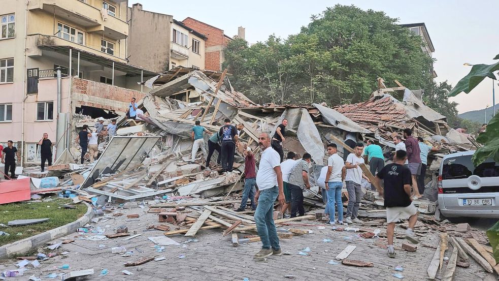 Menschen beseitigen in Sindirgi die Trümmer eines eingestürzten Gebäudes. Foto: Bahadir Demirceviren/IHA/AP/dpa