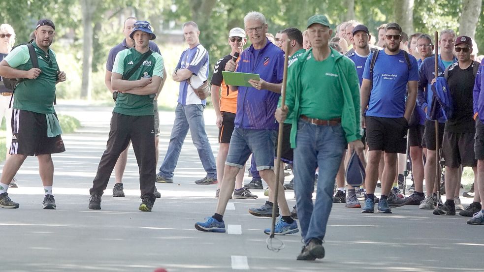 Frido Walter mit Mikrofon und grüner Mappe in der Hand schickte an beiden Tagen rund 400 Männer und Frauen beim Coordes-Cup auf die Straße. Fotos: Helmut Vortanz