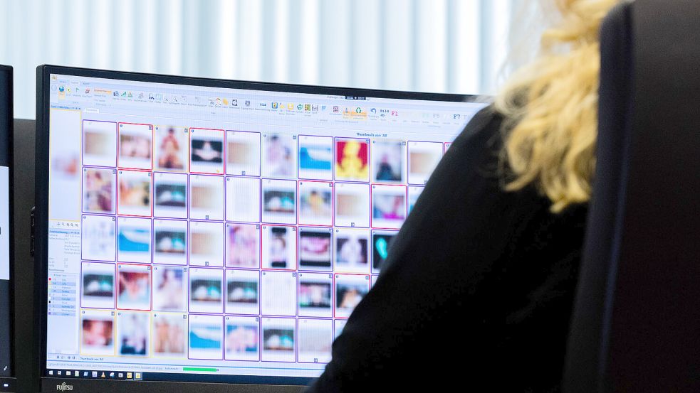 Eine Ermittlerin sitzt vor Monitoren mit unkenntlich gemachten Fotografien, die teilweise sexuellen Missbrauch zeigen, am Hinweistelefon im Landeskriminalamt. Foto: DPA