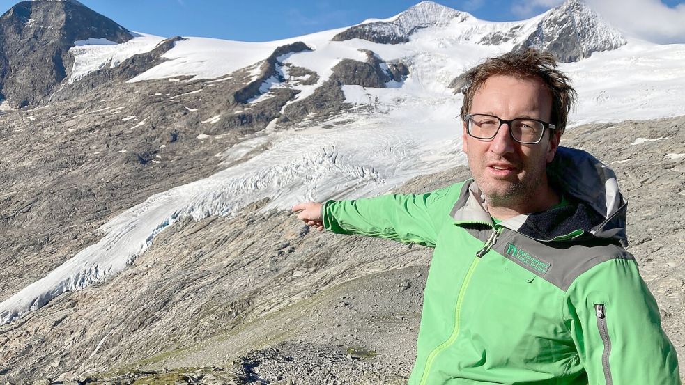 Florian Jurgeit vom Nationalpark Hohe Tauern zeigt von der Neuen Prager Hütte auf den inzwischen weit entfernten Gletscher. Foto: Sabine Dobel/dpa