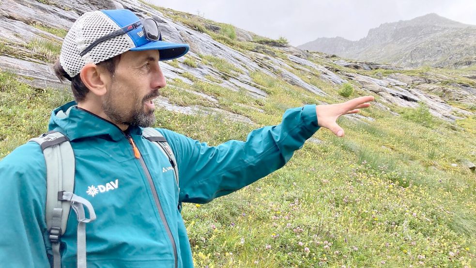 Der DAV-Geowissenschaftler Tobias Hipp zeigt auf die Vegetation - hier war früher Gletscher. Foto: Sabine Dobel/dpa
